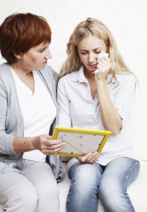 Sad woman looking at the photo frame. Nostalgia, memories, death