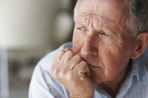 Closeup of an elderly man looking away in deep thought , depression